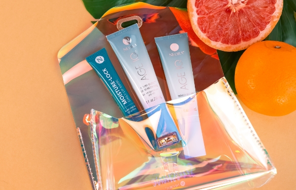 The Summer Skin Essentials Set shown on a pale orange background with citrus fruit.  